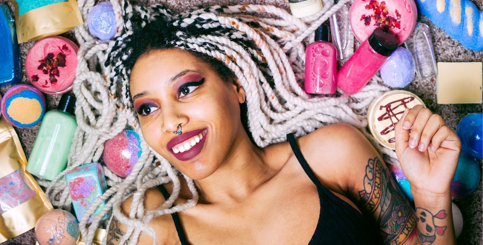 Imagem de um amulher negra de tranças deitada e sorrindo