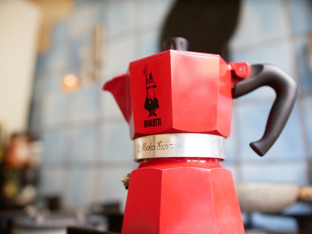red coffee maker on brown wooden table red coffee maker on brown wooden table